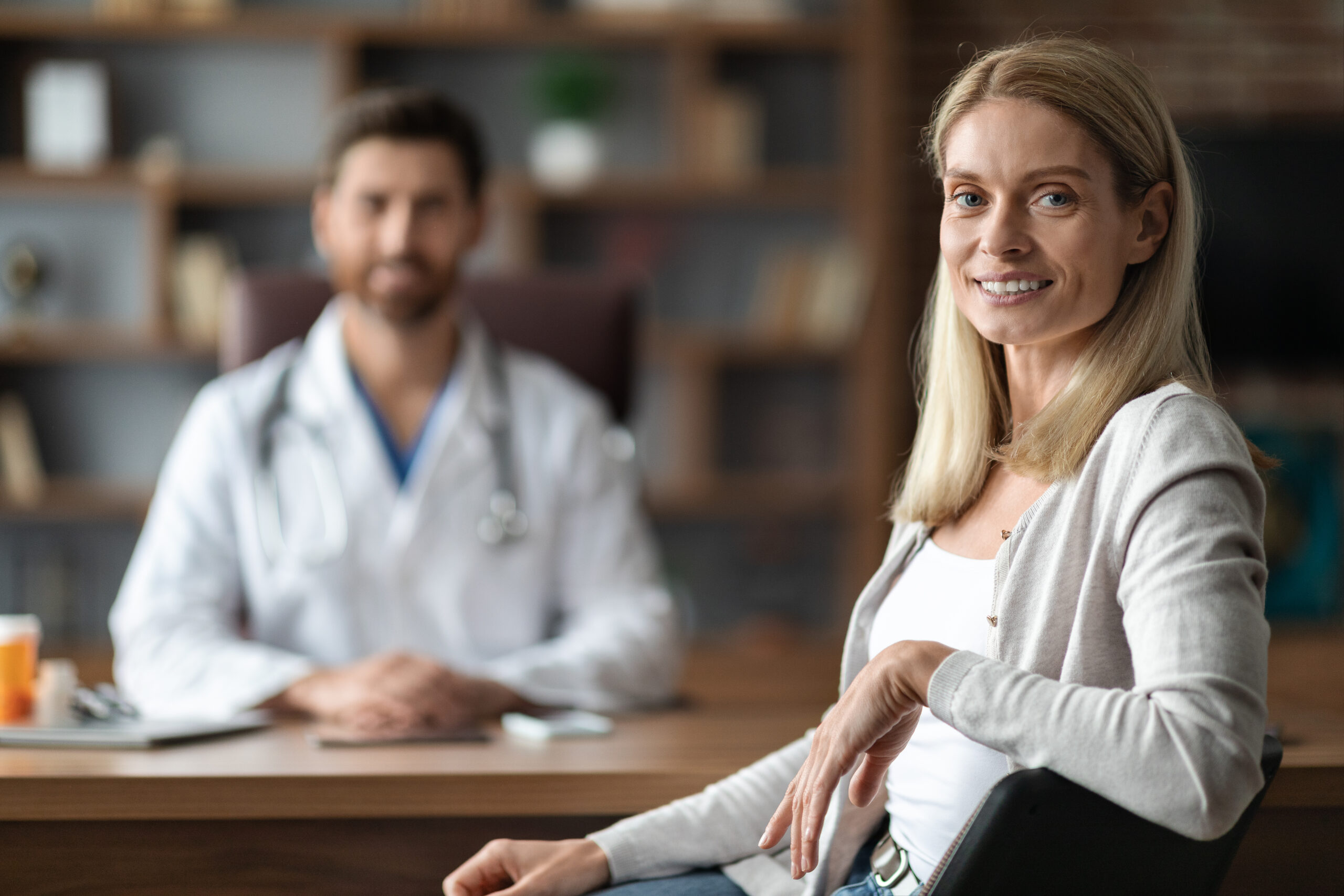 Portrait Of Happy Young Female Patient Sitting At Doctor's Office